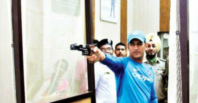 dhoni while shooting by a pistol