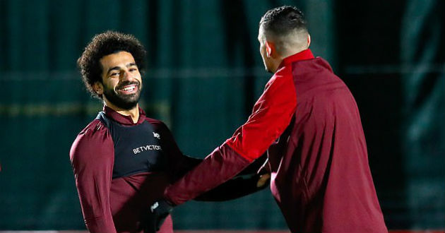 salah smiles during the session as he stretches alongside lovren