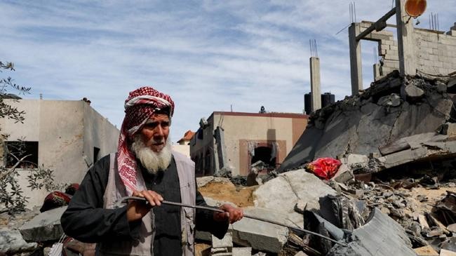 a palestinian stands at the site of an israeli strike on a house