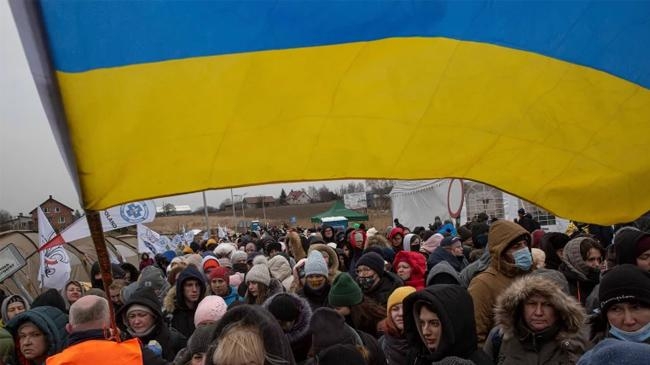 a ukrainian volunteer holds a ukrainian flag