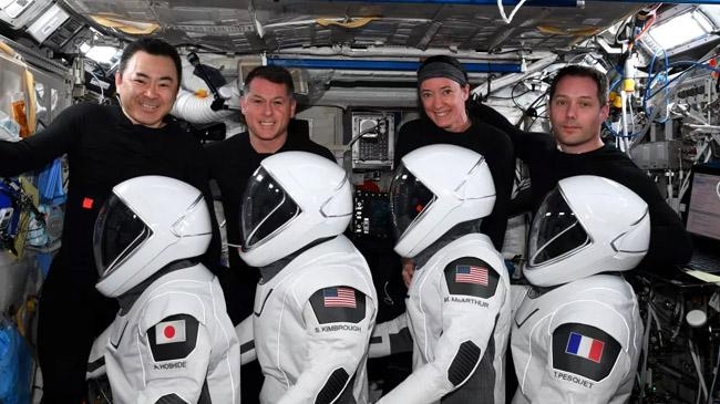 four astronauts waiting wearing diaper