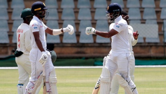 karunaratne and oshada fernando punch gloves during their partnership