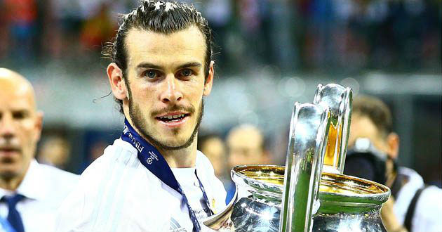 bale poses wth cl trophy