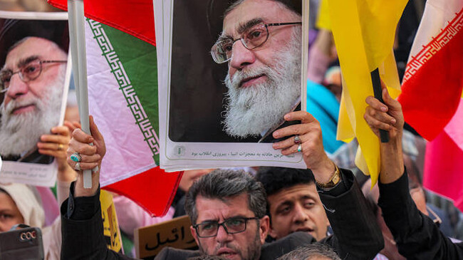 a demonstrator holds a picture of irans supreme leader