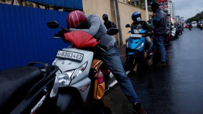 a man waits in a queue to buy petrol due to fuel shortage in colombo