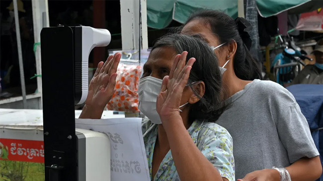 a woman checks her temperature at the central market in phnom penh