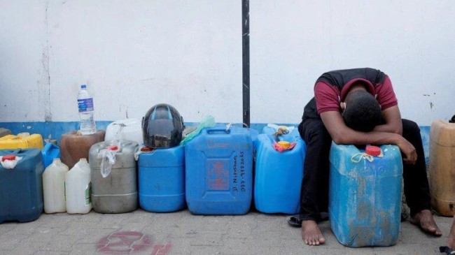 a man rests while waiting in a line to buy diesel near a fuel station in colombo sri lanka