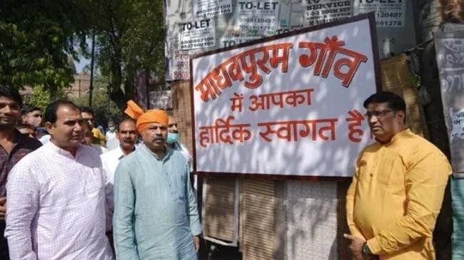 adesh gupta posed in front of a board