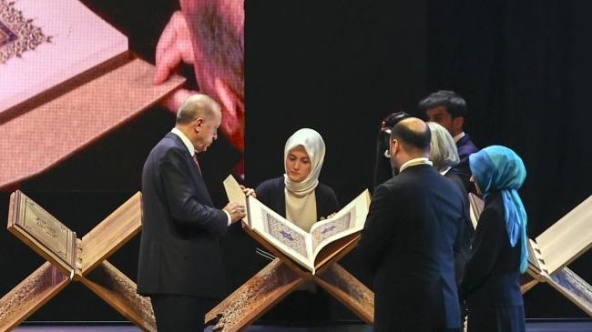 erdogan examines the book on stage during the ceremony