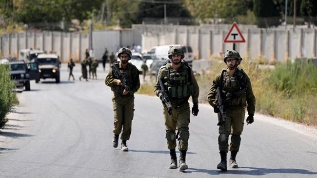israeli forces walk near the site where a soldier was killed