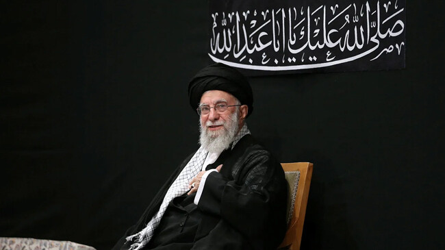 khamenei can be seen on stage dressed in black