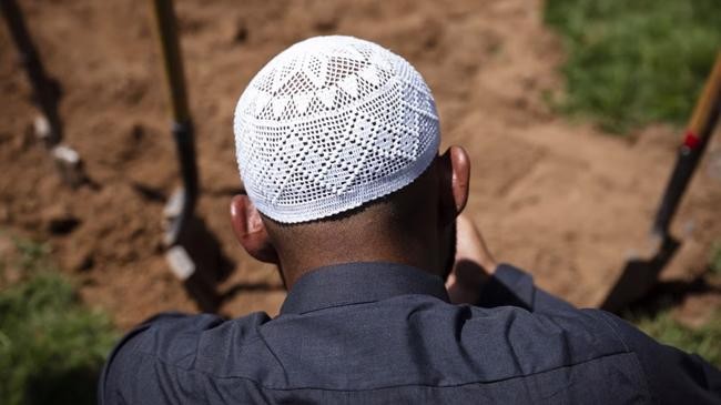 men pray over the grave