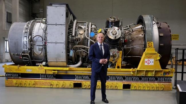 oiaf scholz stands next to a gas turbine