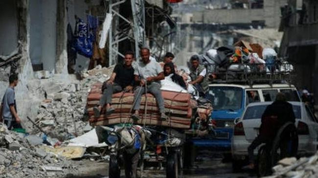 palestinians ride a cart with belongings as they flee their homes