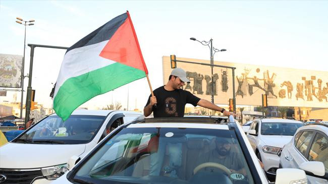 people stage a demonstration and carry palestinian flag in baghdad