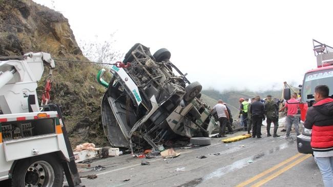 rescuers secure a bus from falling down a ravine