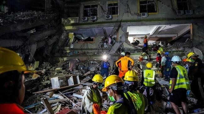 rescuers work at the site of a damaged building
