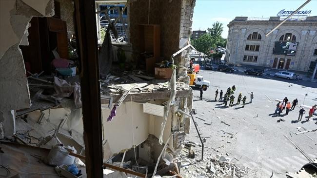 rescuers working at a destroyed apartment building