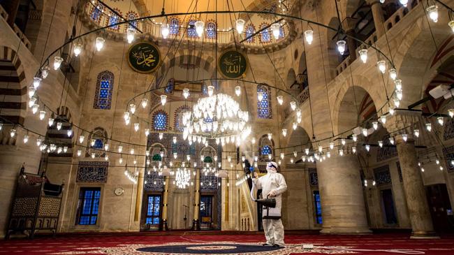 saudi mosque a man is giving sanitizer
