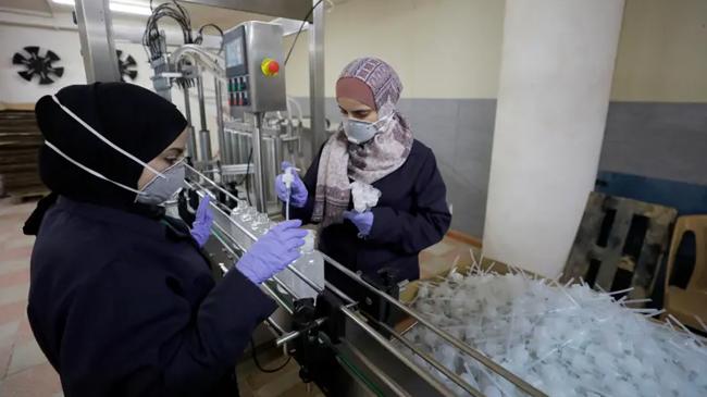 two workers in palestine creating sanitizer