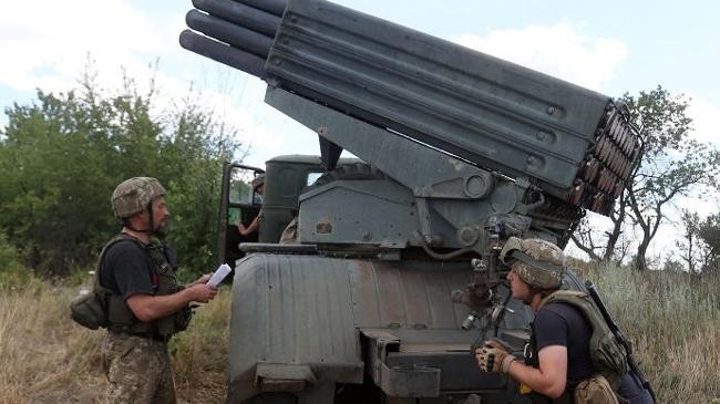 ukrainian soldiers prepare to fire a multiple rocket launcher