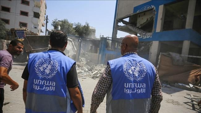unrwa employees and palestinians inspect a damaged school