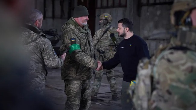 zelenskyy shakes hands with a soldierat a bakhmut